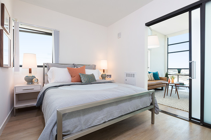Small space bedroom with stainless steel Portica bed, adjacent to the condo living room