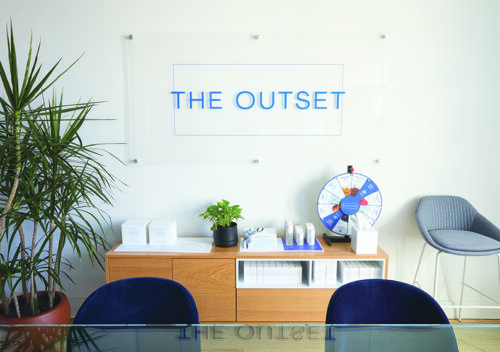 The Outset company sign behind their front desk.