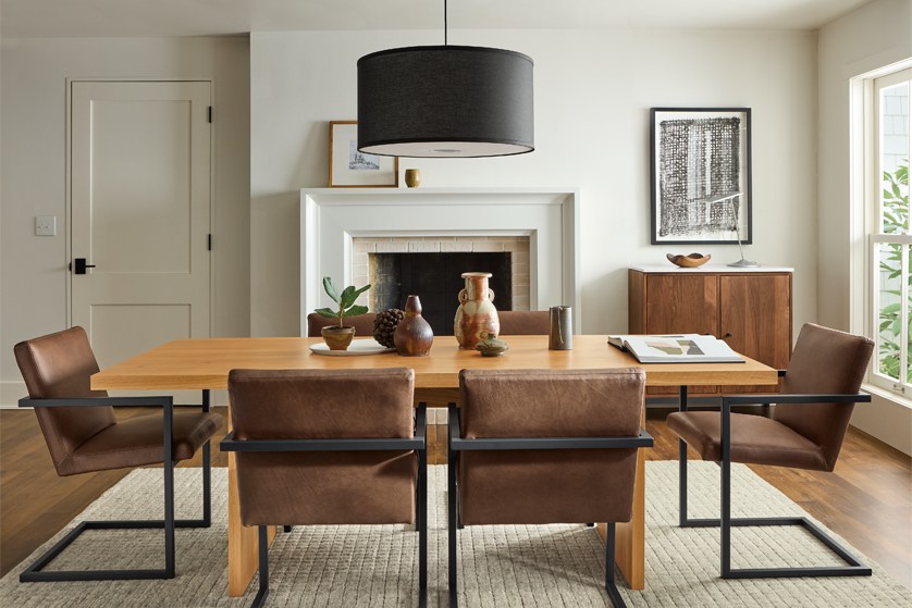 Corbett wood dining table and leather chairs in a dining room with a fireplace.
