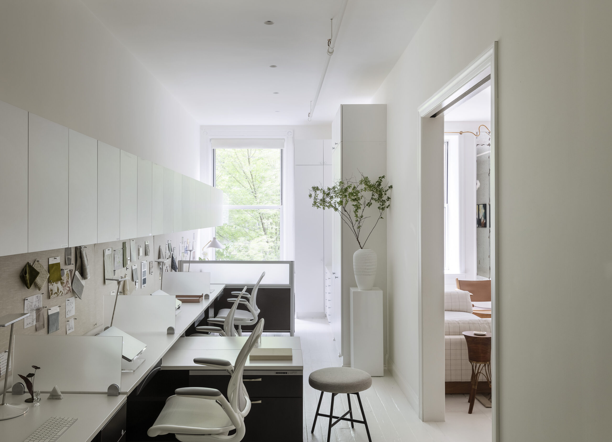 Narrow office with two desk and two office chairs.