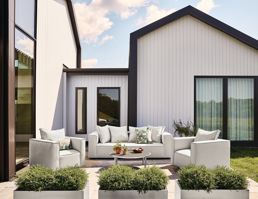 Oasis sofa and chairs in front of modern farmhouse.